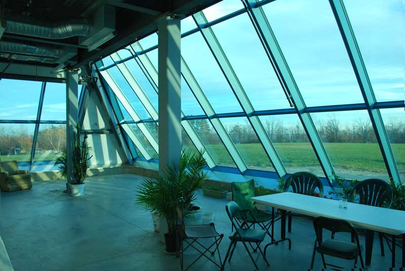 	A shot from within the first floor of our glass-fronted pyramid.
 Though there are only a few plants right now, our greenhouse space will soon be filled to the brim with a wide variety of plants and flowers.